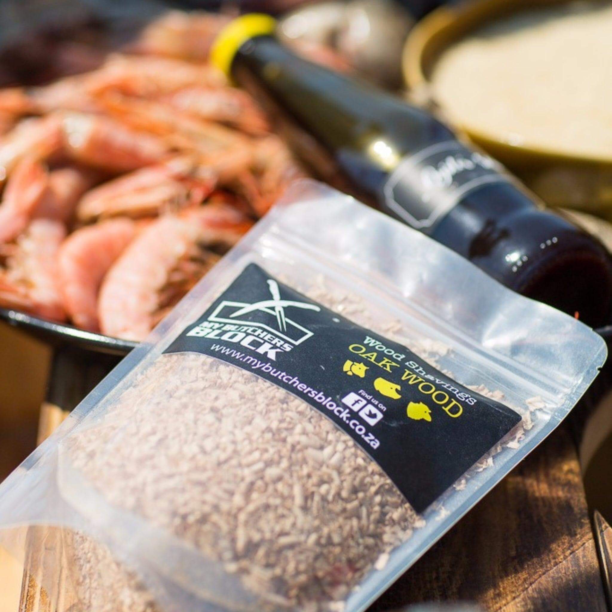 Smoking wood shavings in a transparent bag, enhancing barbecue flavors with fresh seafood in the background.