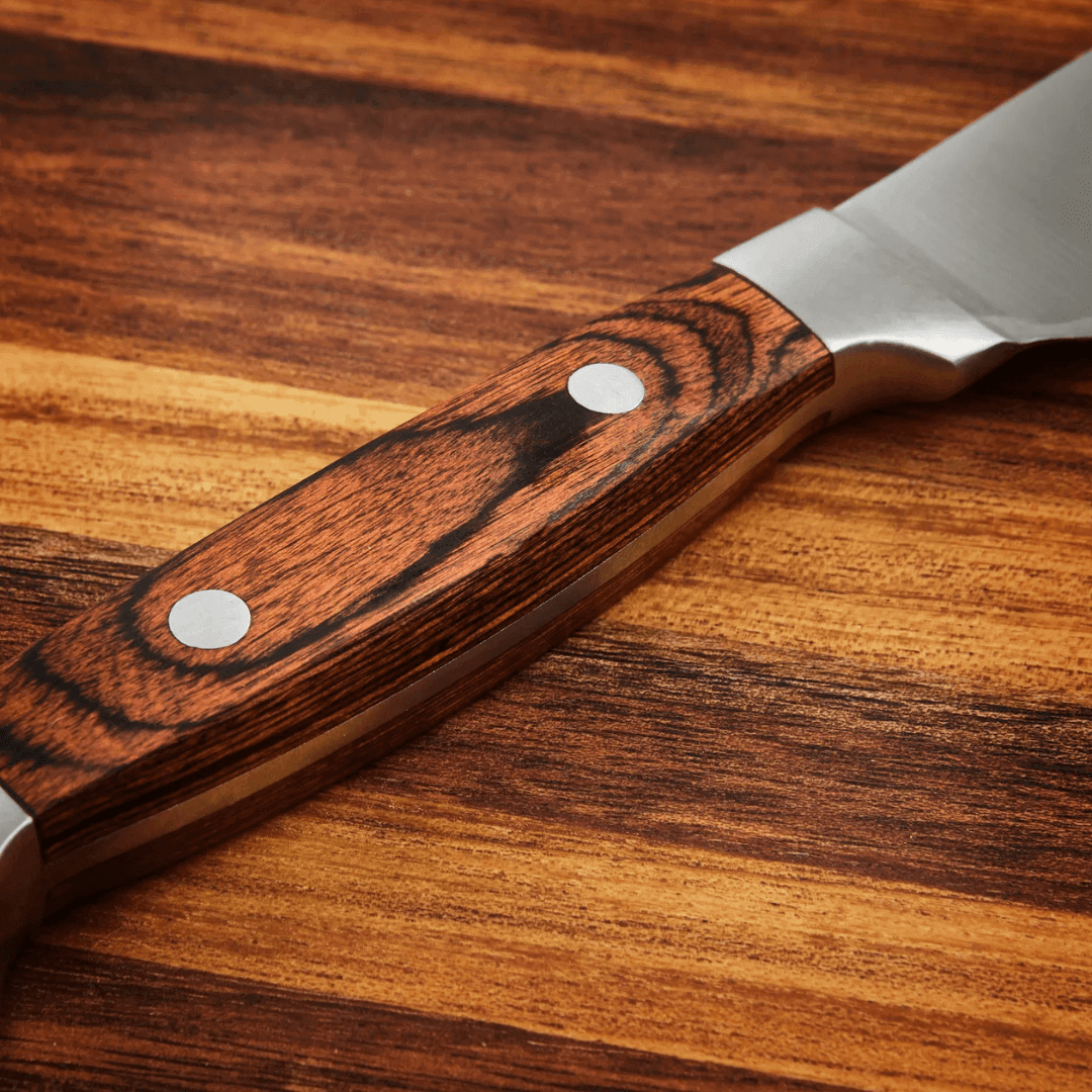 Close-up of a high-quality steak knife with a wooden handle and stainless steel blade, showcasing craftsmanship and design.