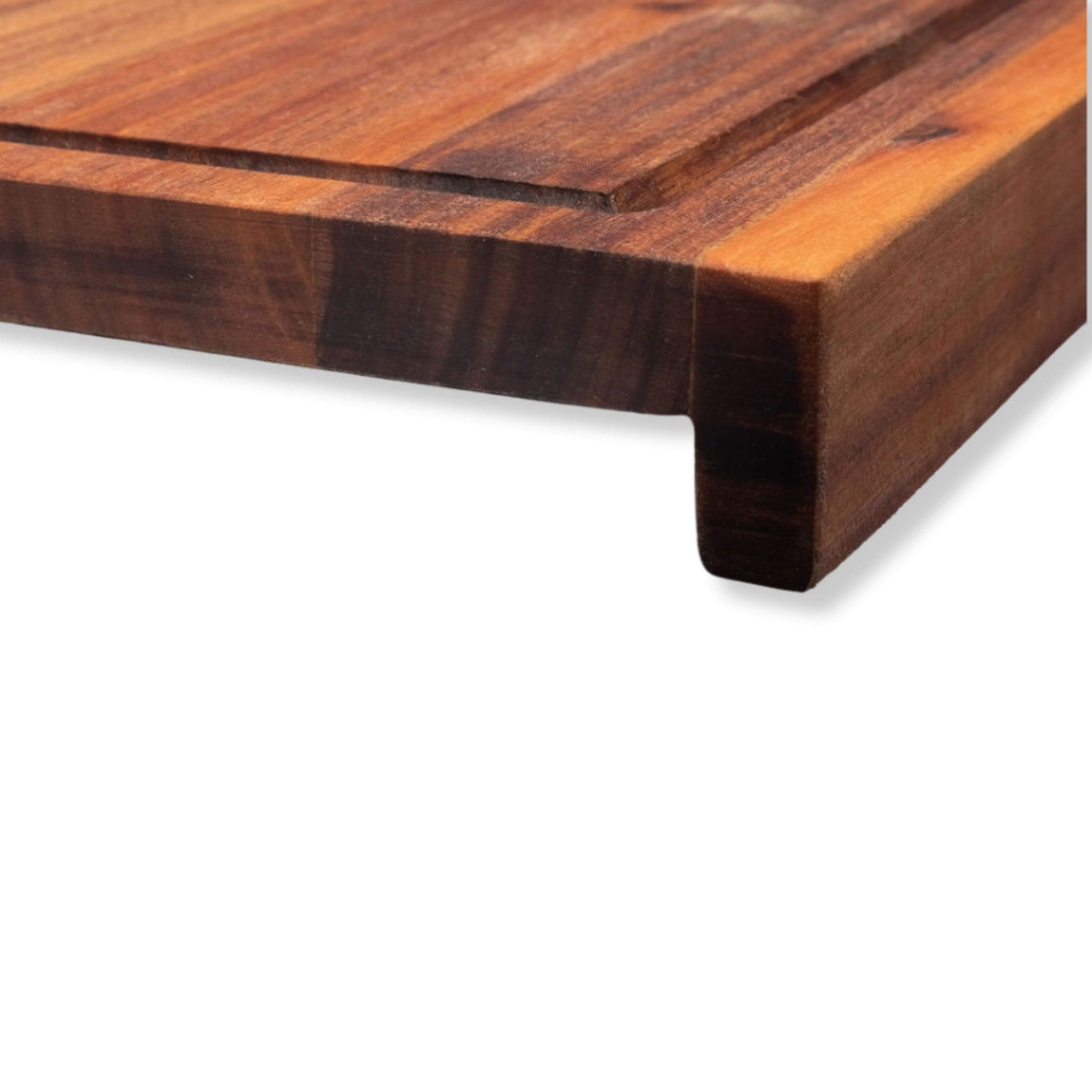 Close-up of a wooden chopping board with a lip and juice groove for precision cutting and stability in the kitchen.