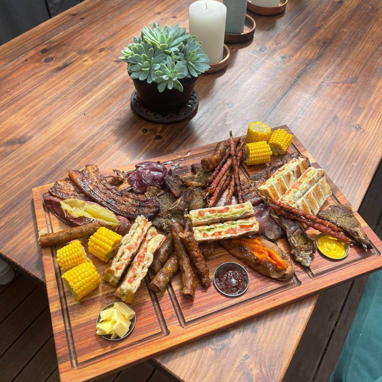 Delicious variety of grilled meats and sides served on Shisanyama Plankie Braai Board Large, perfect for sharing.