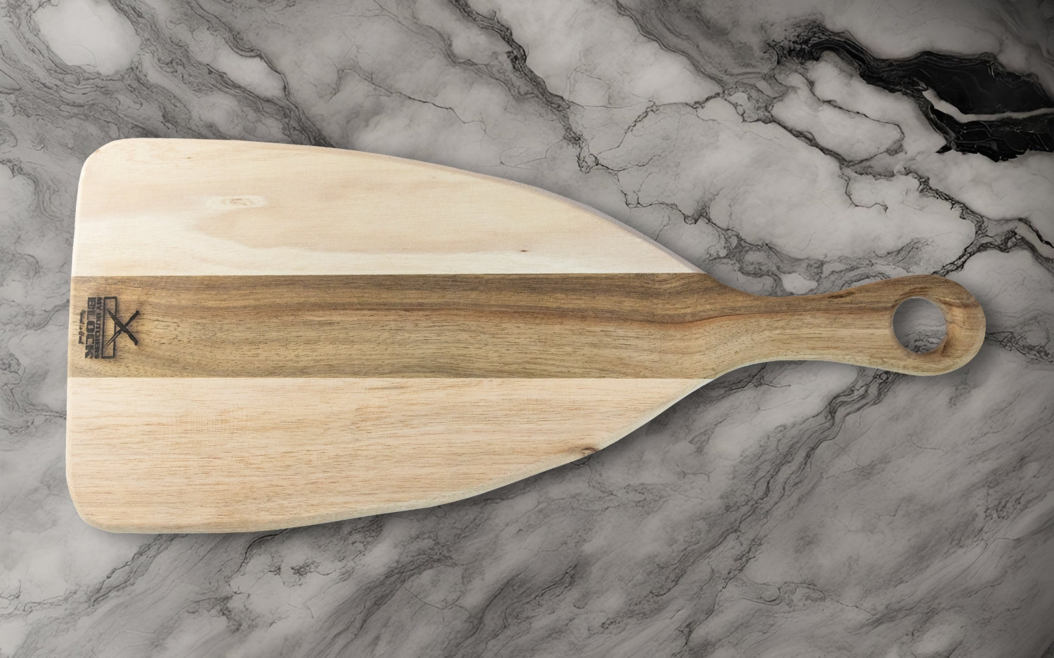 Natural wood serving paddle on a marble countertop, showcasing a modern design and elegant craftsmanship.