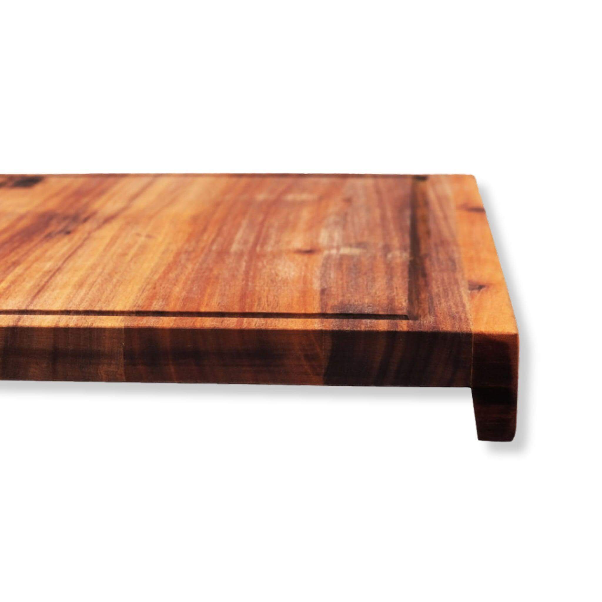 Close-up of a wooden chopping board with a lip and juice groove, ideal for kitchen meal prep.