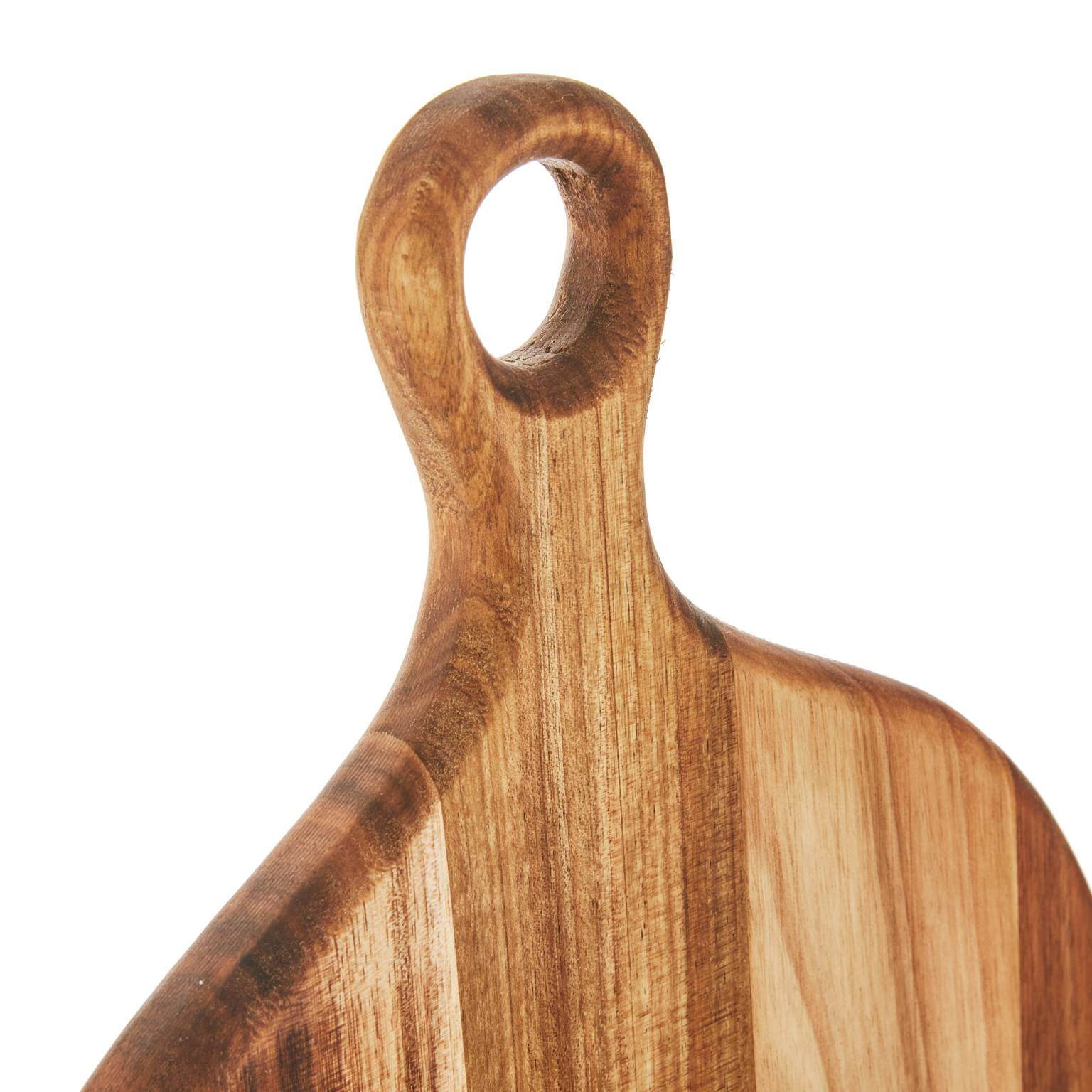 Close-up of a round wooden serving board handle with a hole for easy hanging and display.