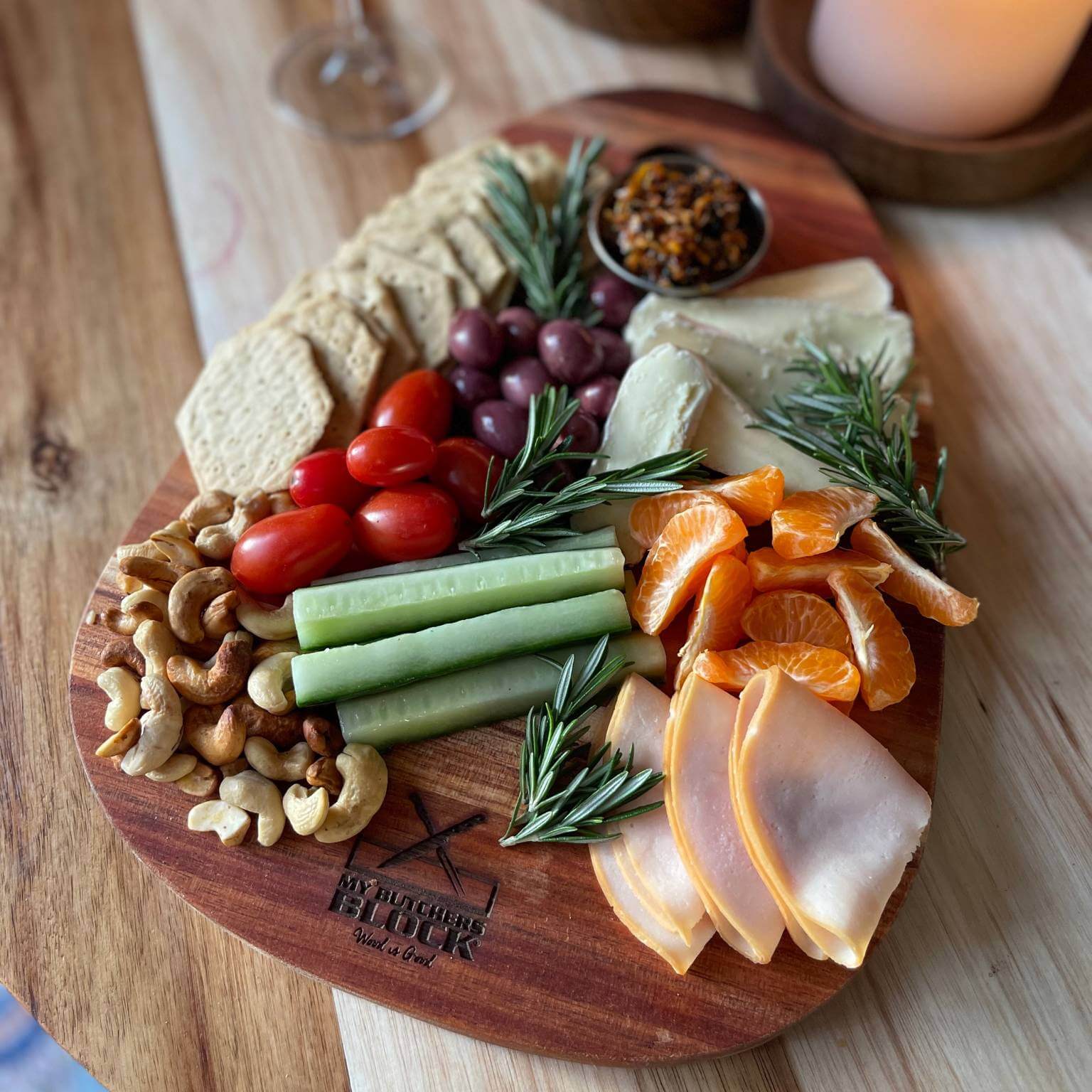 Charcuterie spread featuring meats, cheeses, fruits, and nuts on a rustic paddle board.