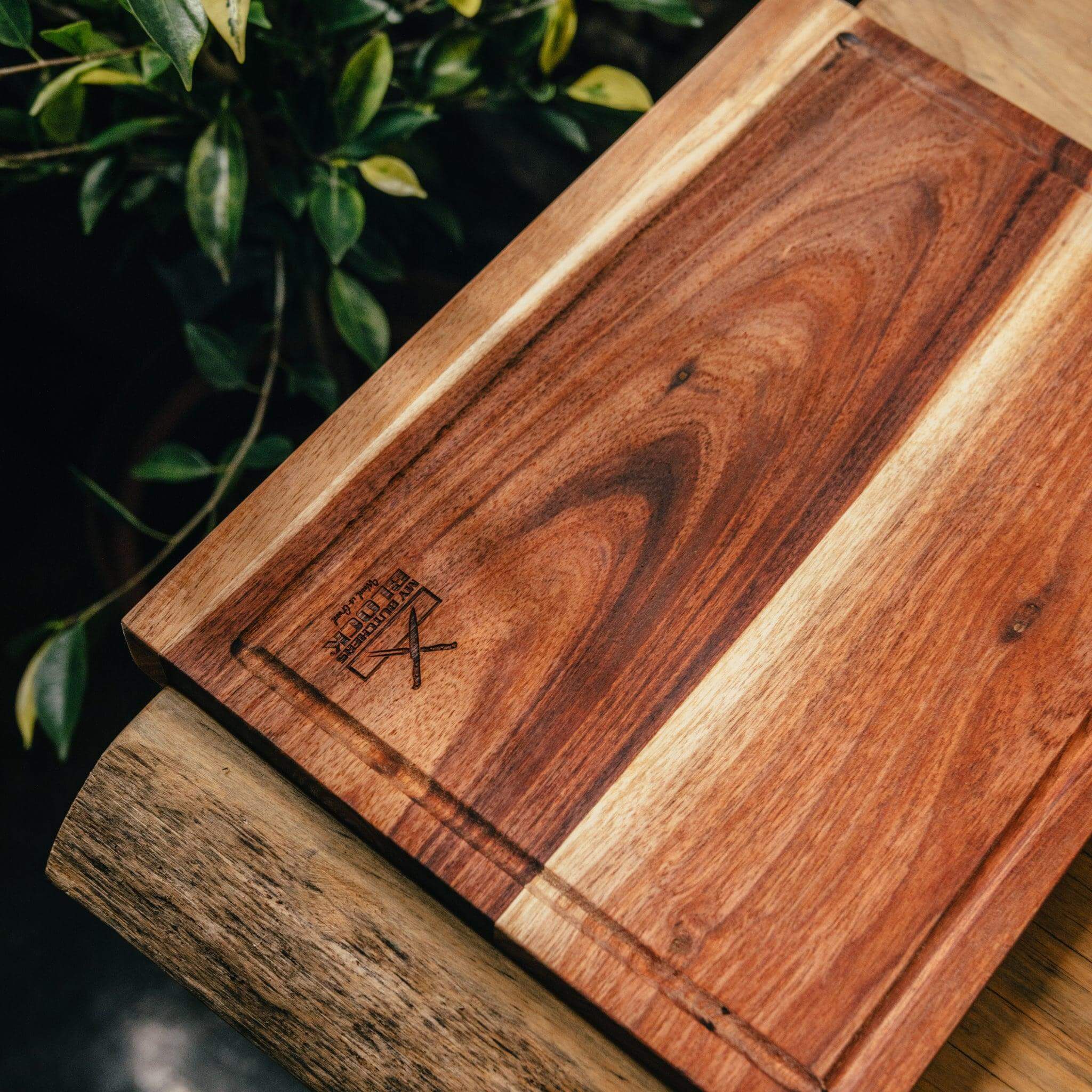 Close-up of a wooden chopping board with a lip and juice groove, showcasing its craftsmanship and design features.