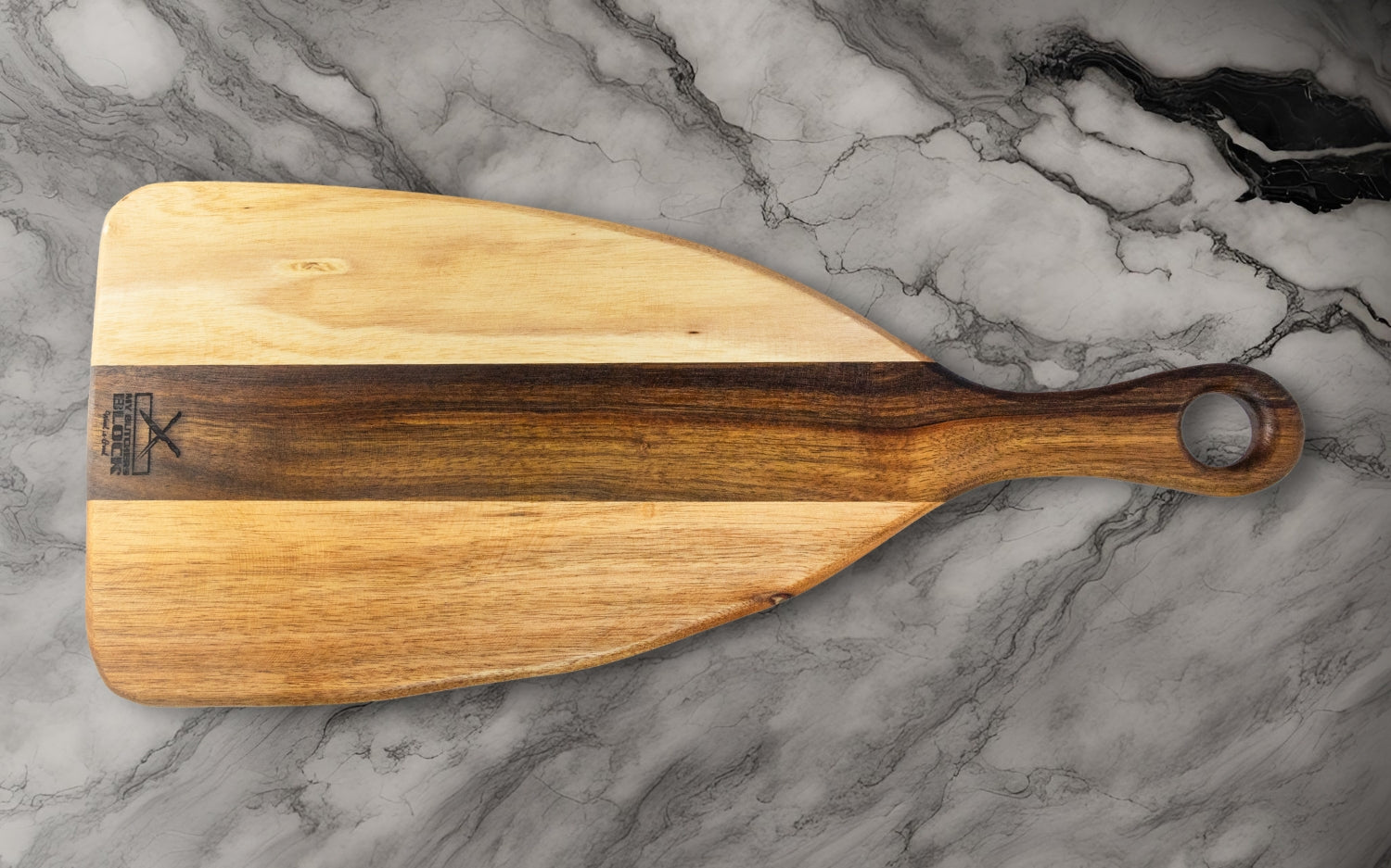 Wooden pizza paddle with a sleek design on a marble countertop background.