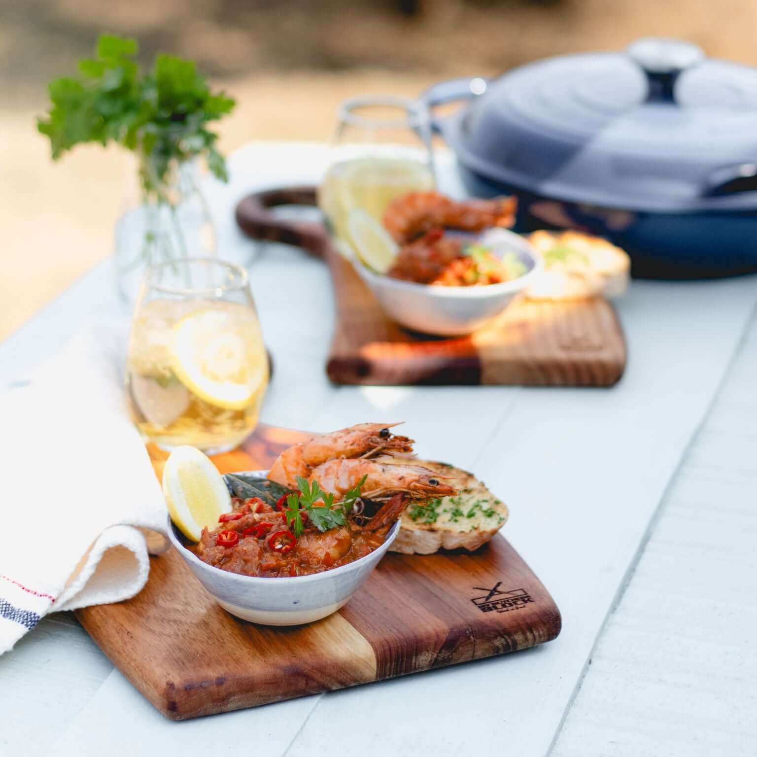 Elegant wooden nesting boards serving shrimp and lemon, perfect for gatherings and space-saving in the kitchen.
