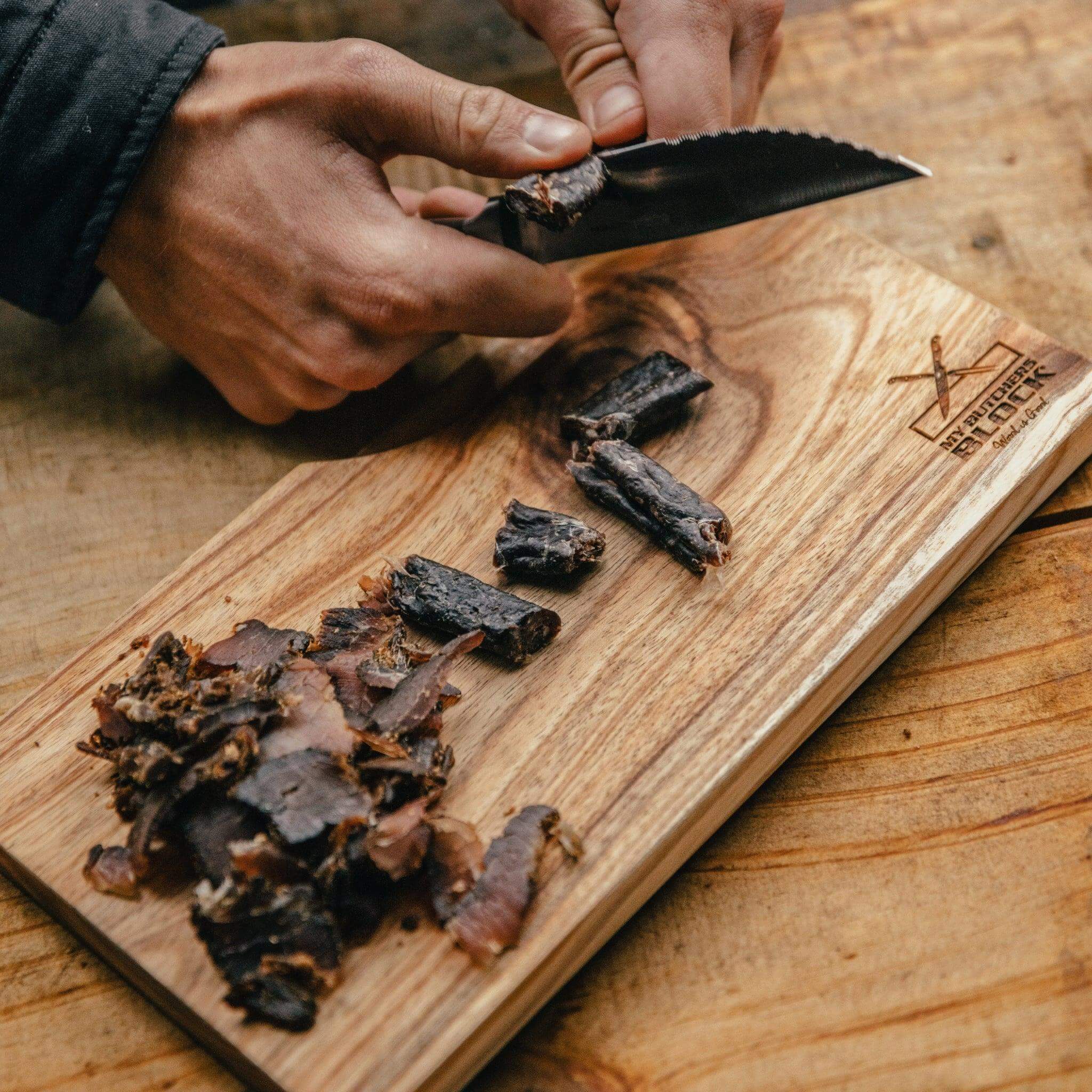 Hand slicing biltong on the wooden Biltong Board & Knife Combo