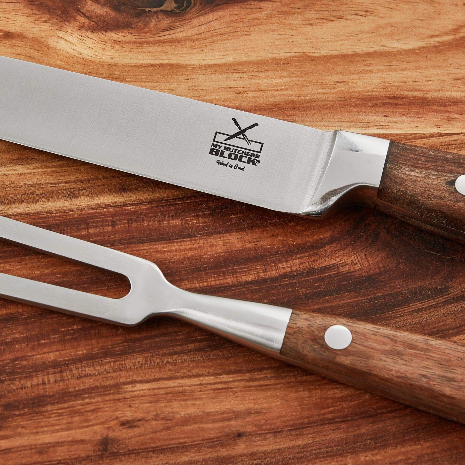 Carving knife and fork set on wooden surface, showcasing stainless steel blades and ergonomic handles.