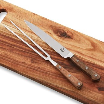 Premium carving knife set featuring stainless steel knife and fork on a wooden cutting board.