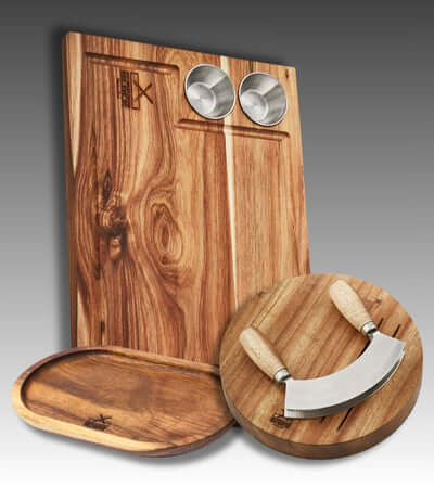 Elegant wooden cutting board set with a stainless steel knife and two metal dipping bowls.