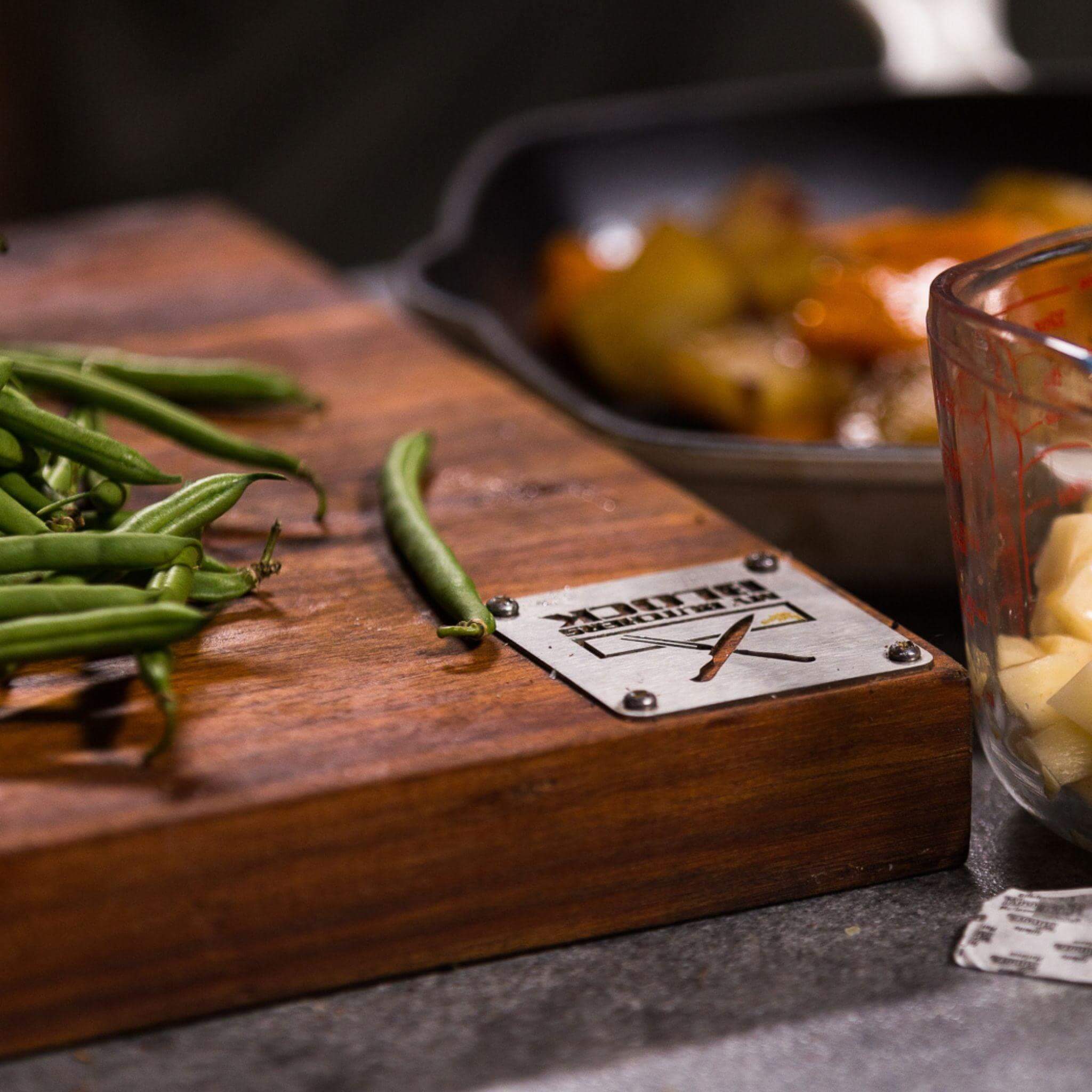 Close-up of Grand Daddy chopping block with green beans and dishes for BBQ prep, showcasing premium kitchenware.