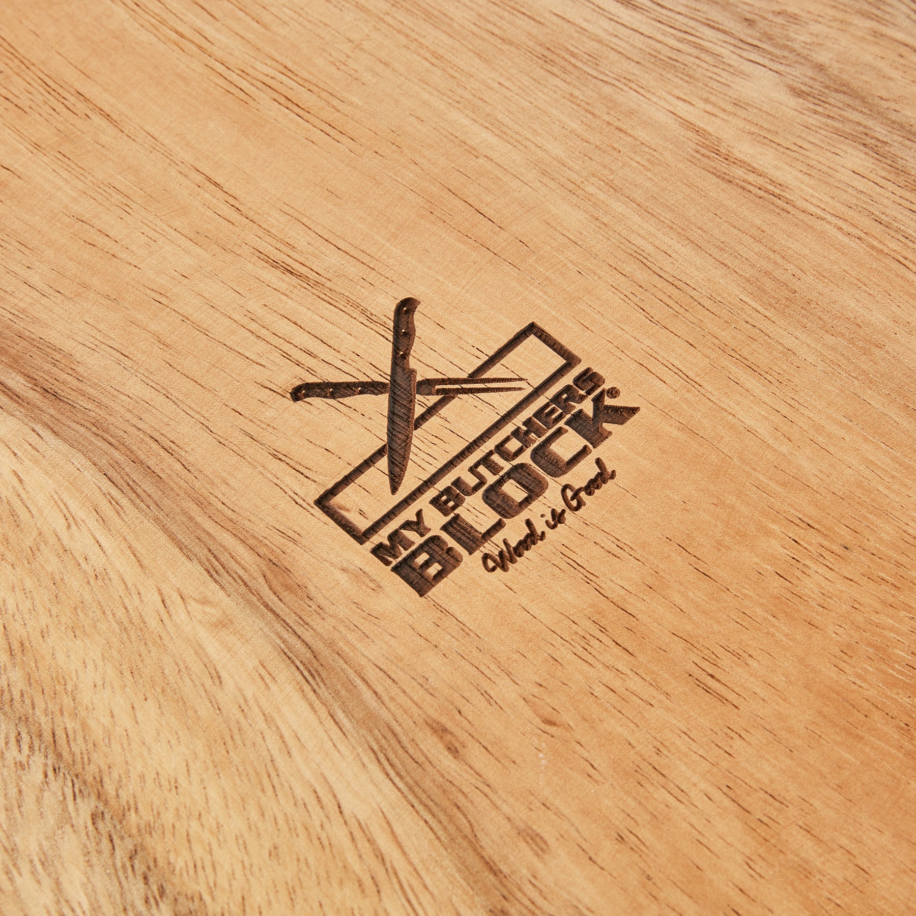 Close-up of My Butcher's Block logo engraved on a wooden cutting board surface.
