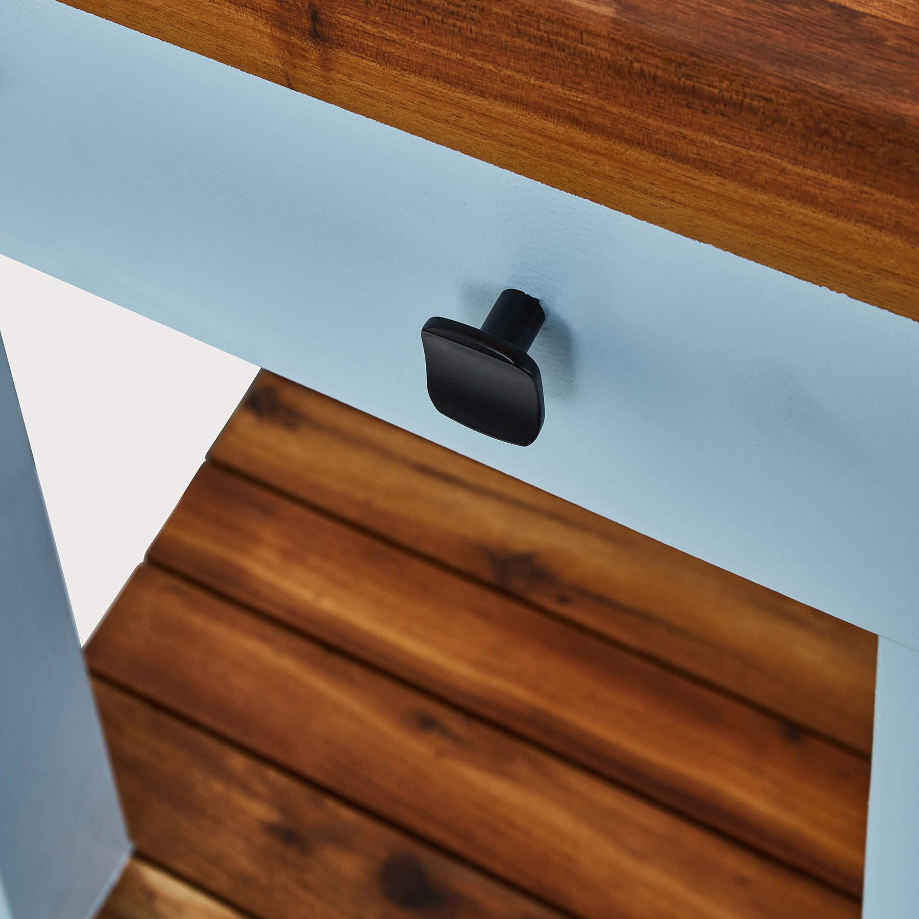 Close-up of the drawer handle on the compact Butcher's Bench with a wooden top and powder-coated frame.