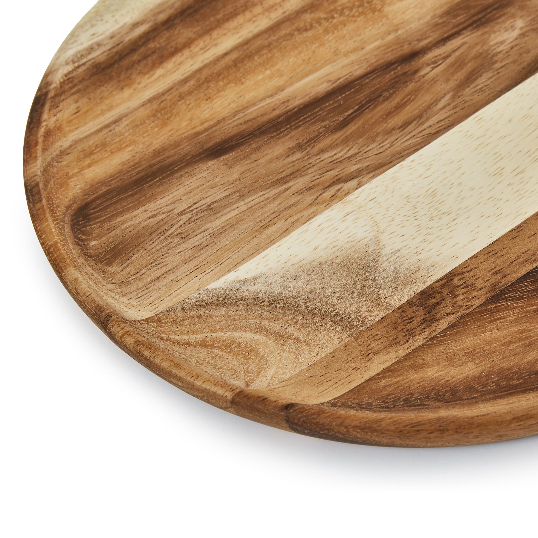 Close-up of a handcrafted round wooden dinner plate showcasing natural Acacia wood patterns.