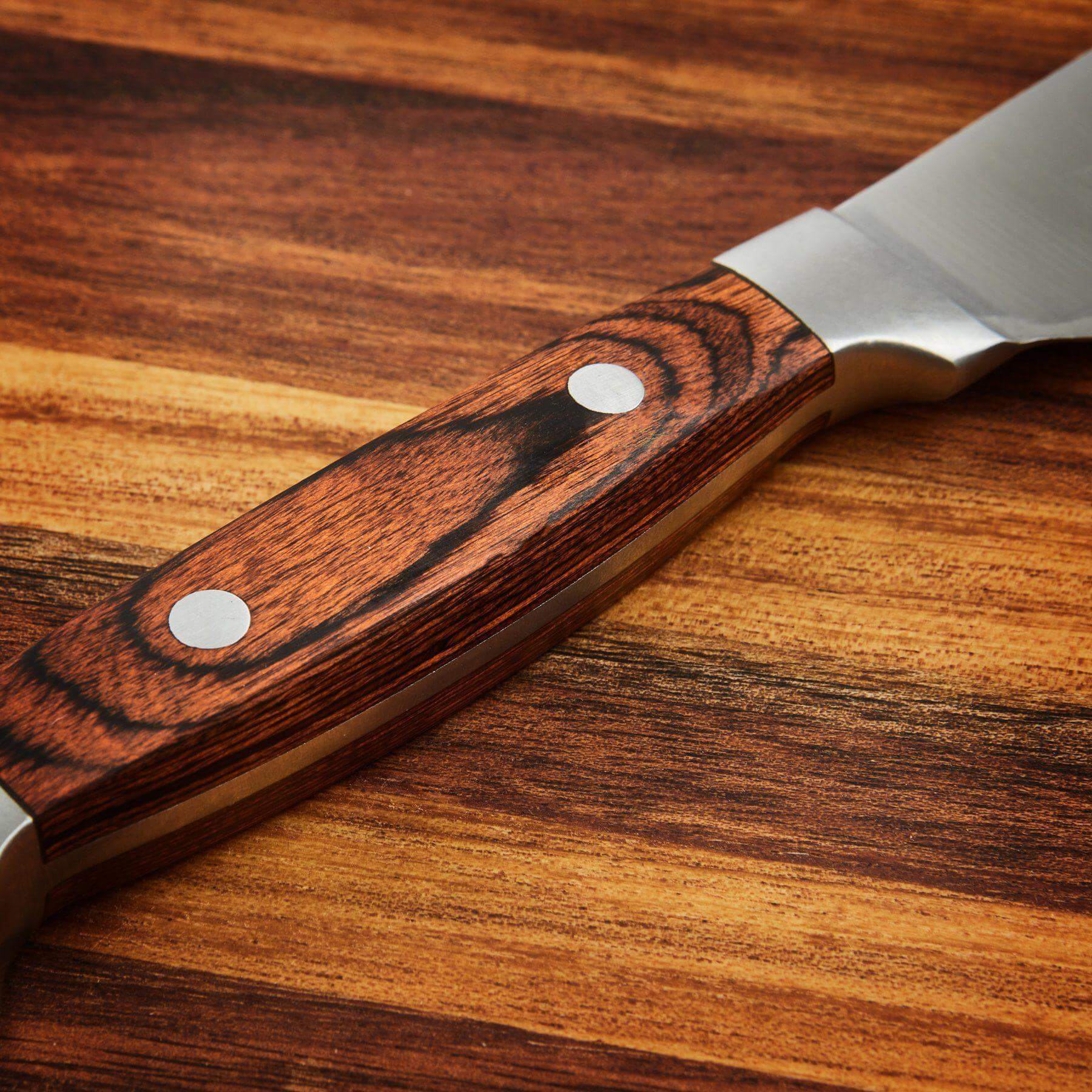 Close-up of a stylish wooden handle of a steak knife, showcasing elegant grain and stainless steel blade.