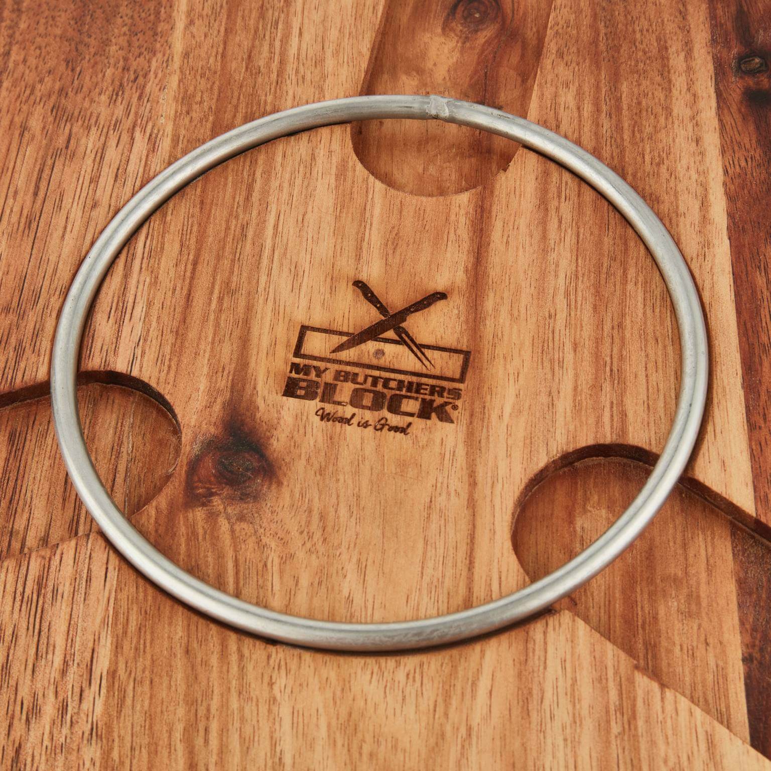Stainless steel ring on a wooden chopping board with My Butchers Block engraving.