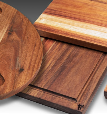 Elegant wooden serving boards and a circular platter, showcasing rich grain patterns and rustic charm.