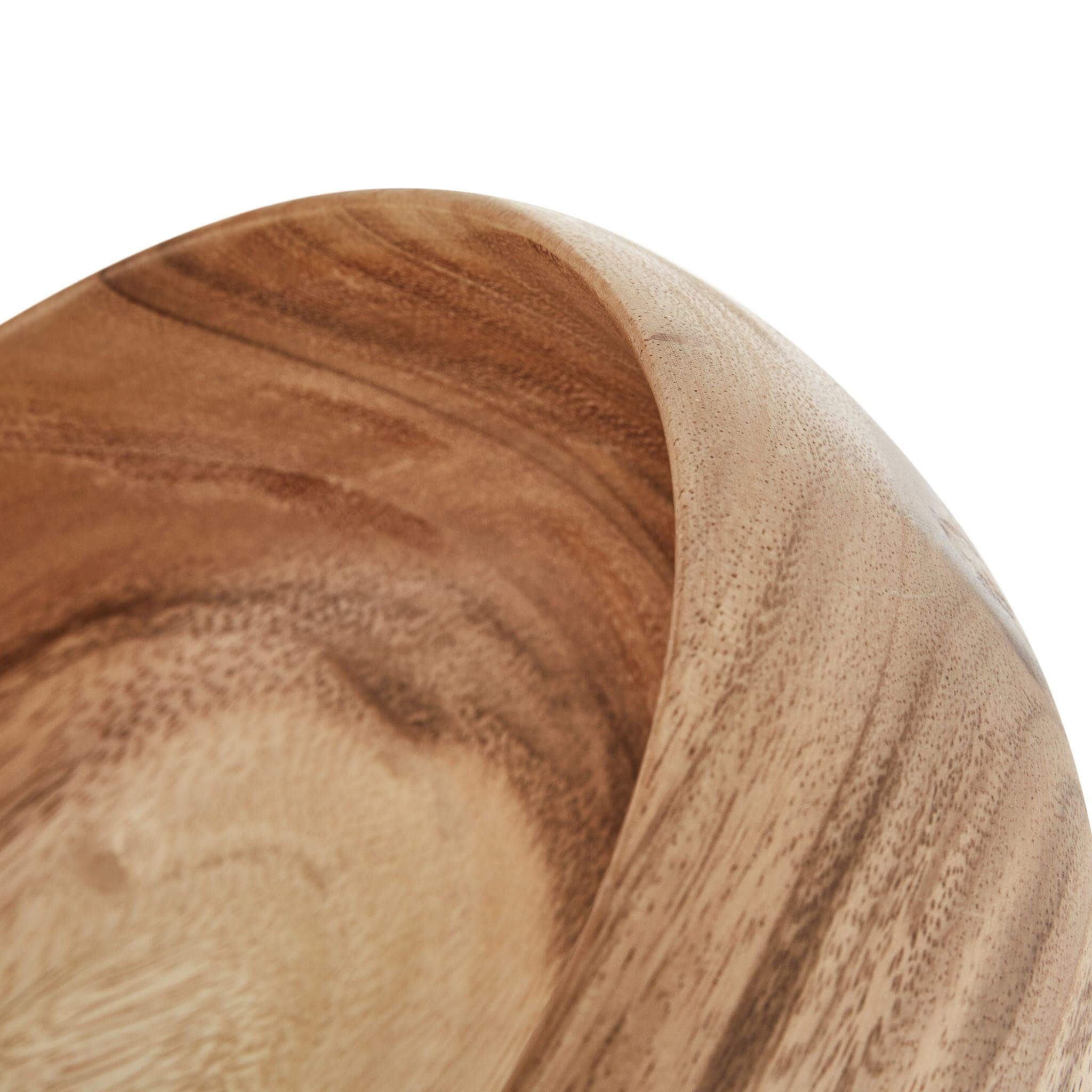Close-up of a handcrafted small wooden bowl showcasing its smooth finish and unique grain patterns.