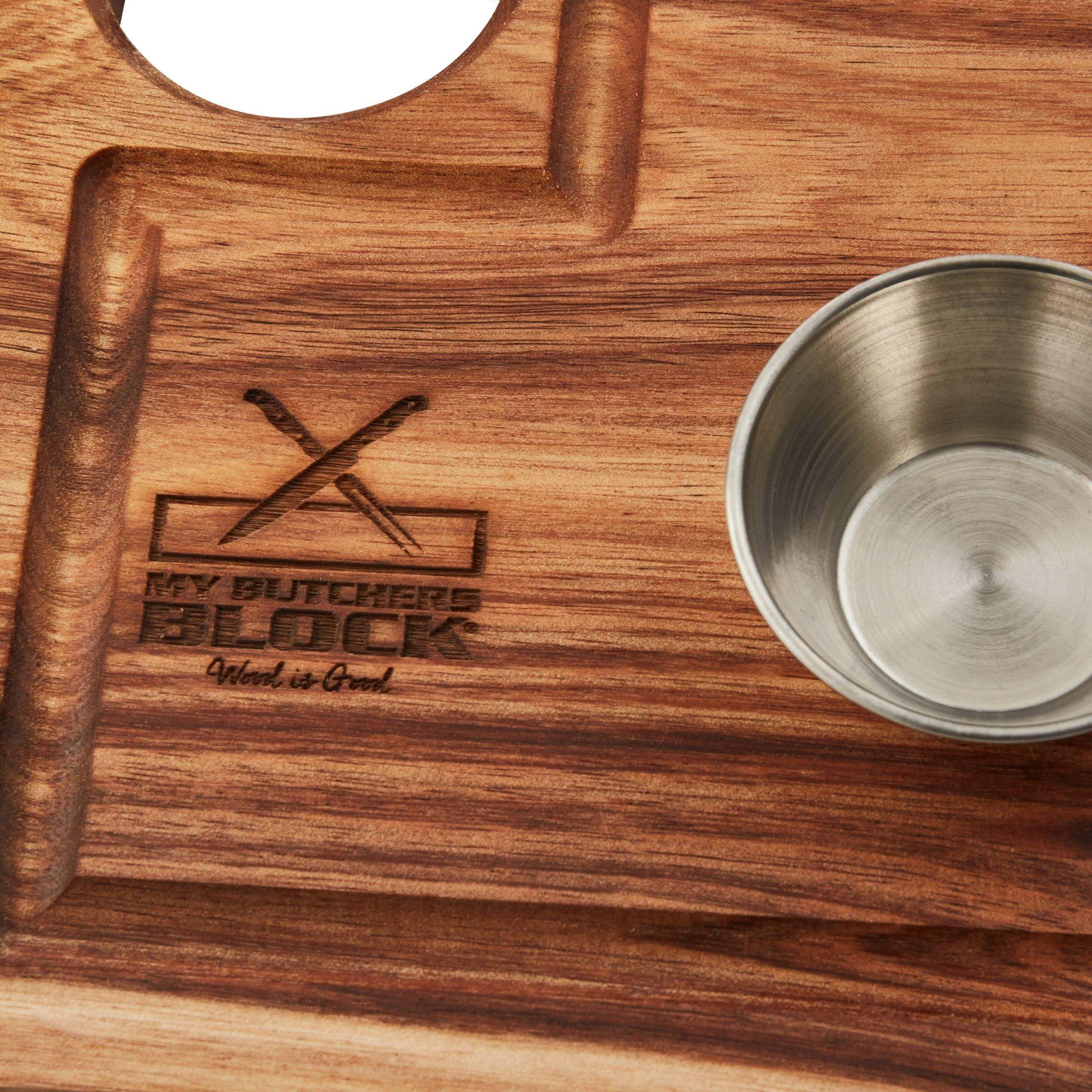 Close-up of a wooden steak board featuring a metal dipping bowl and engraved logo for My Butchers Block.