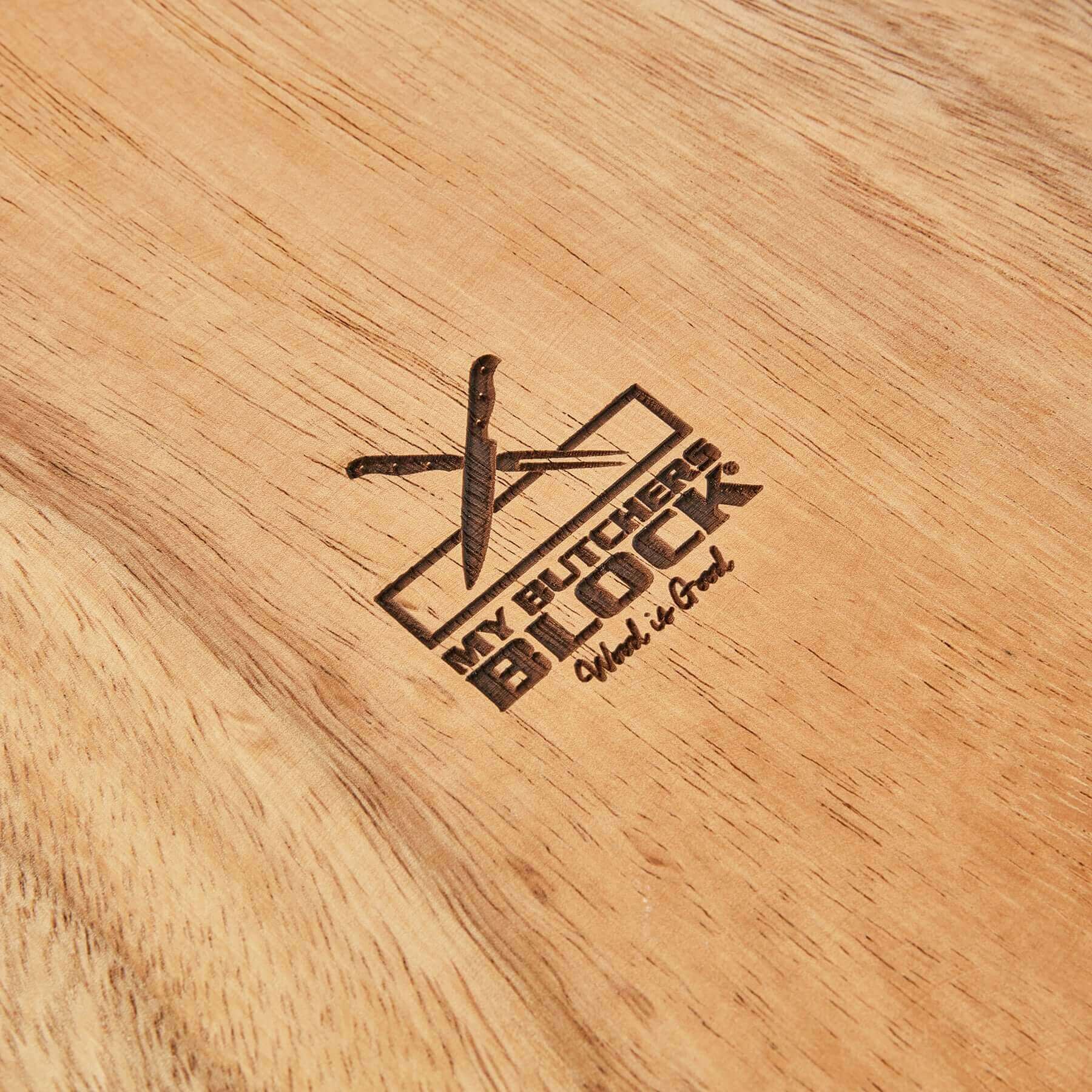 Close-up of a wooden cutting board featuring the My Butcher's Block logo engraved on its surface.