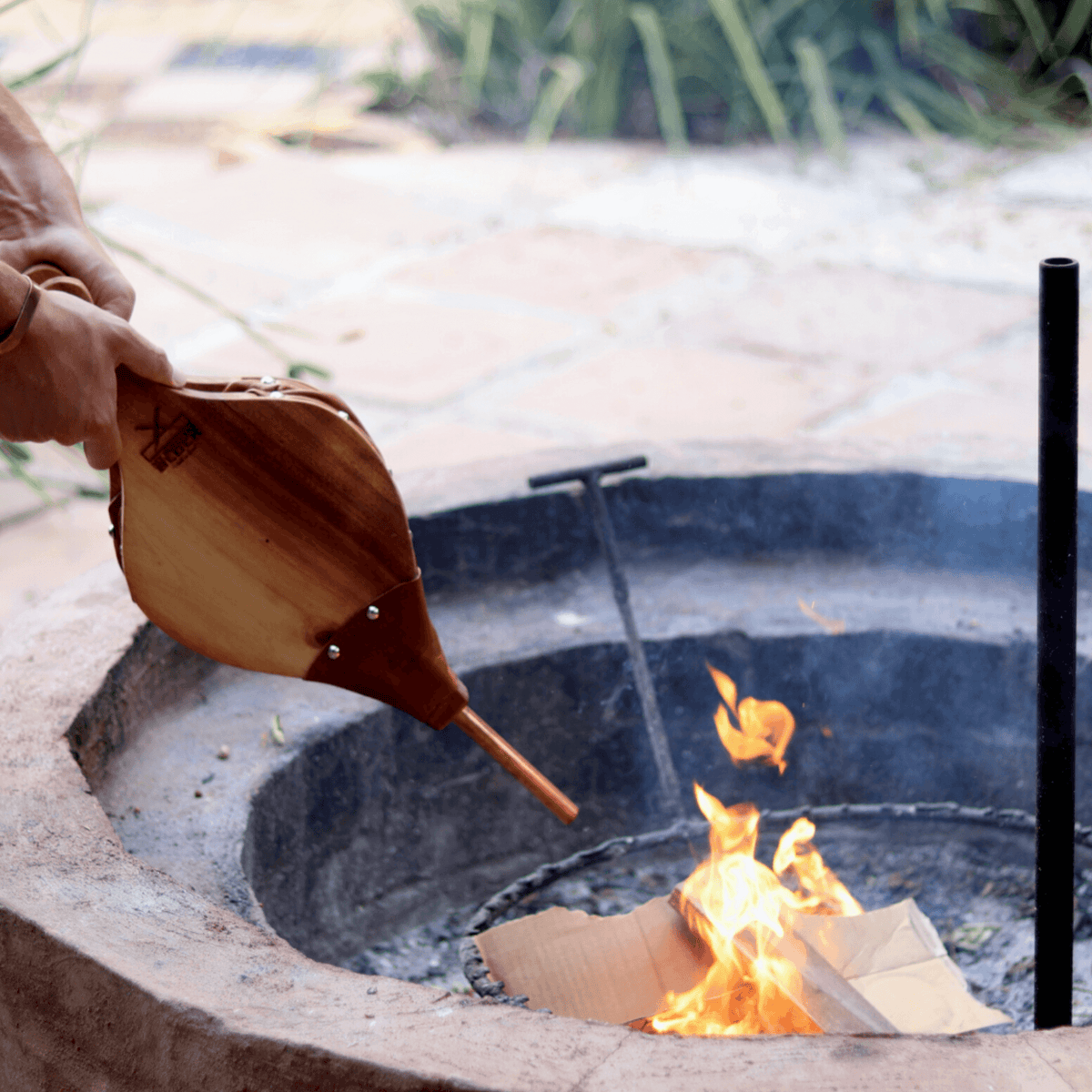 Bellow being used to start a fire at a braai area.