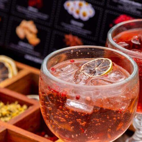 Refreshing cocktail served in a glass with ice and a lemon slice, highlighting vibrant flavors for a home happy hour.