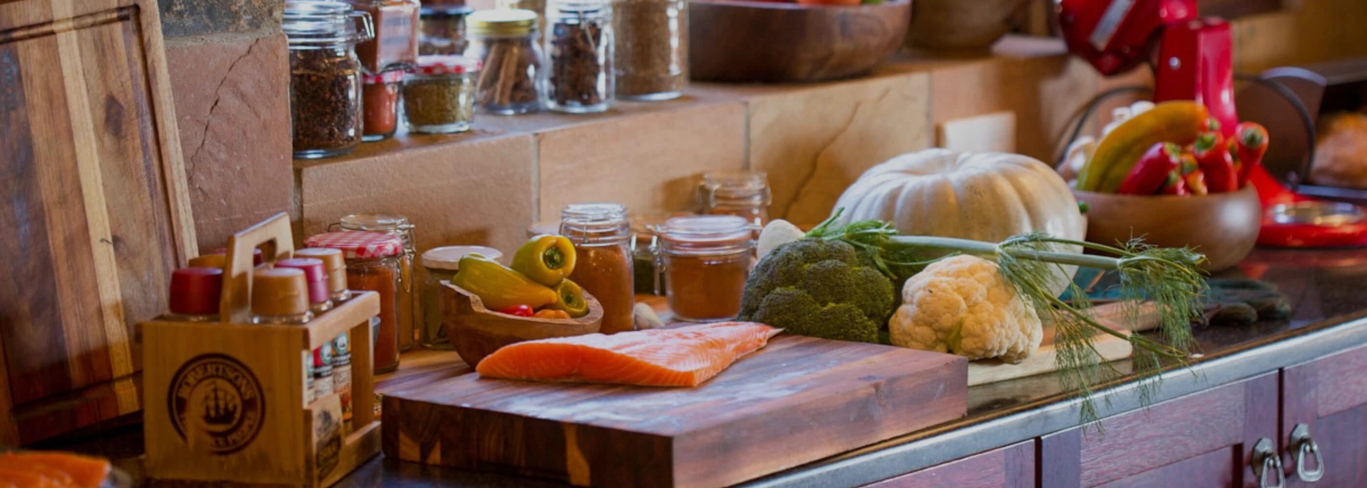 Kitchen counter with various ingredients and a cutting board.