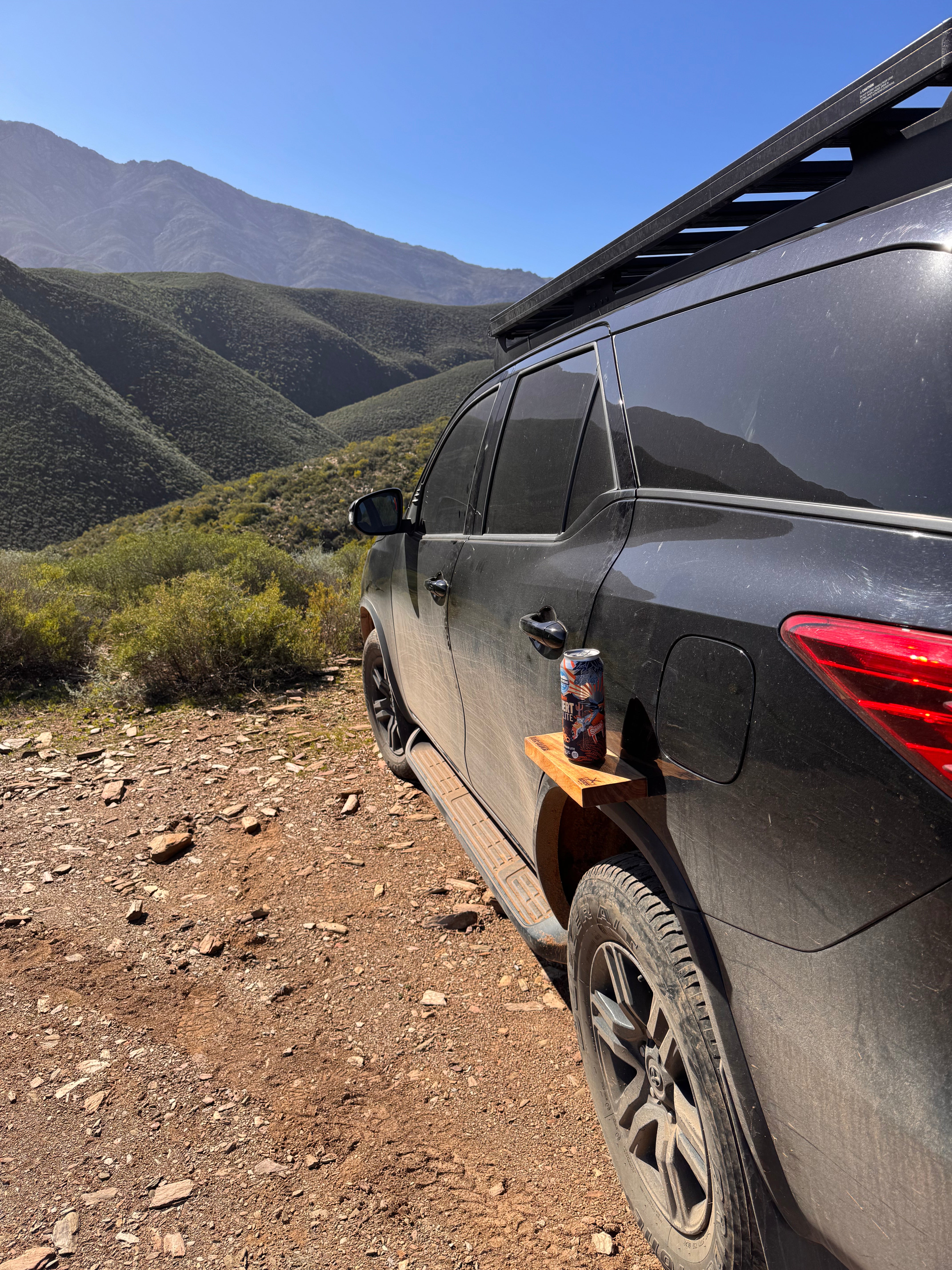 SUV on a mountain trail with a can on a wooden block