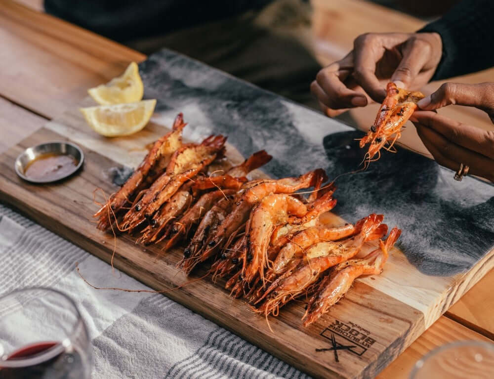 Handy Andy In Blue Resin serving board with grilled shrimp and lemon slices, perfect for kitchen essentials and braais.